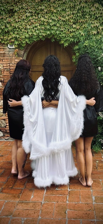 Steph in white with two friends, arm-in-arm